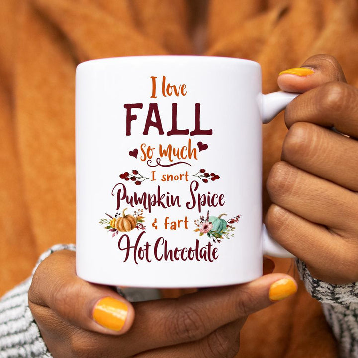 white mug that says I love fall so much, I snort pumpkin spice and fart hot chocolate being held by person with yellow nail polish